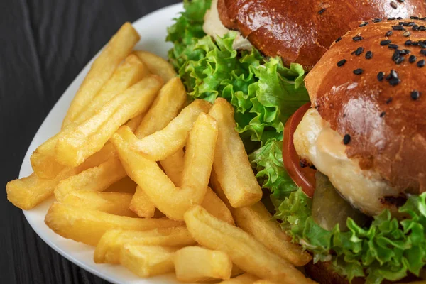 Savoureux hamburgers appétissants sur un terrel blanc avec des frites sur un fond gris — Photo