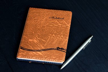 Kalemle siyah bir arkaplanda dizüstü bilgisayar