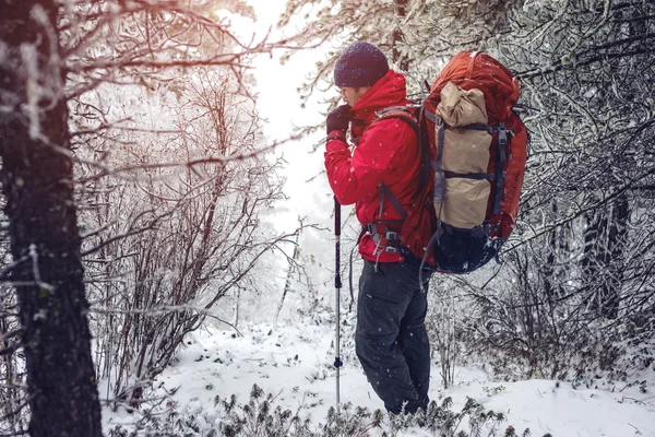 Paisaje invernal. Turista en chaqueta roja va en la colina — Foto de Stock