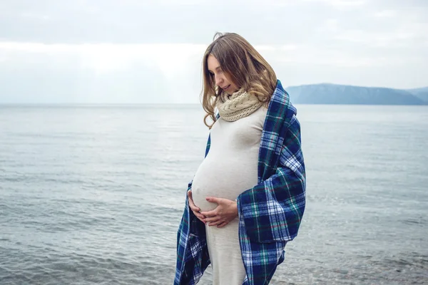 Giovane bella donna incinta avvolta in una coperta — Foto Stock