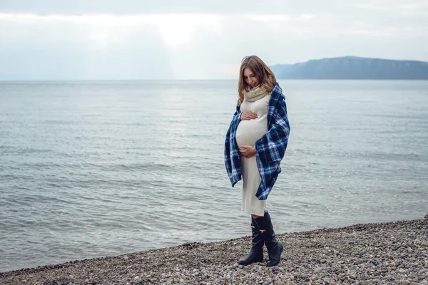 Mladá krásná těhotná žena zabalený do deky — Stock fotografie