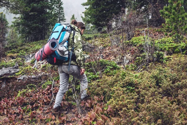 Дівчина з рюкзаком піднімається в гірському лісі — стокове фото