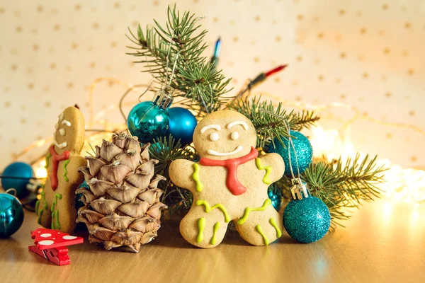 Gingerbread man near Christmas tree with toys by garland — Stock Photo, Image