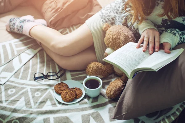 暖かいベッドで本を読んで女の子ソックス コーヒーを飲む — ストック写真