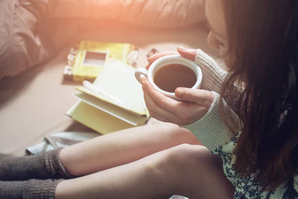 Mädchen liest Buch im Bett mit warmen Socken und trinkt Kaffee — Stockfoto