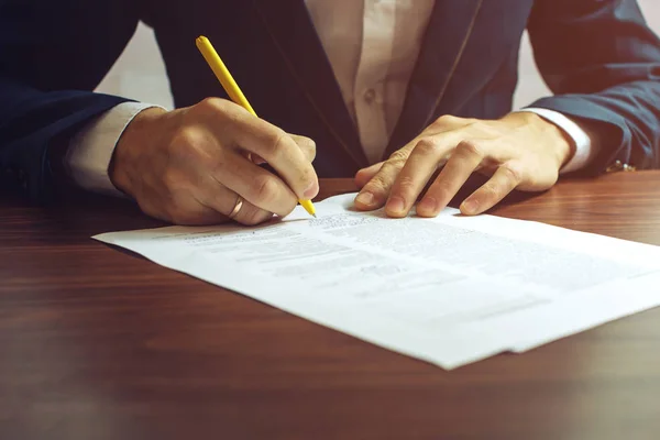 stock image Man businessman signs documents with a pen