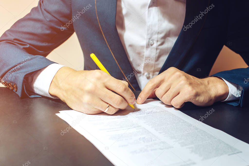 Man businessman signs documents with a pen