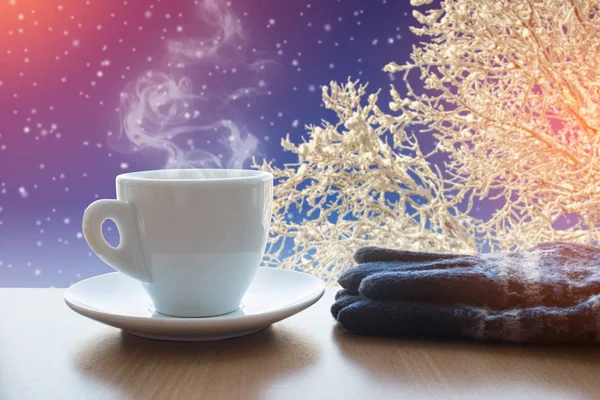 Cup with hot drink and mittens on the winter background — Stock Photo, Image