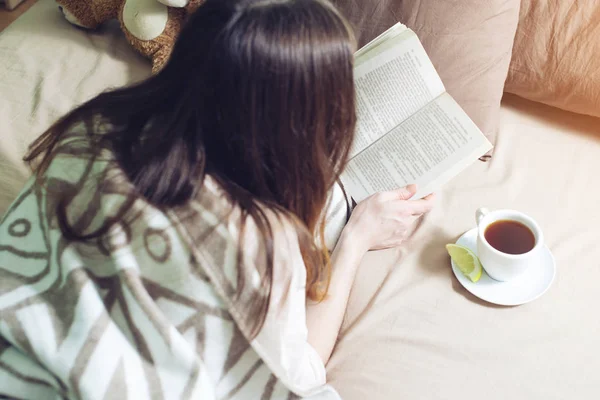 Donna avvolta in un caldo libro di lettura coperta — Foto Stock