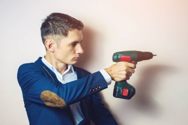 silah gibi bir tornavida tutan takım elbiseli adam