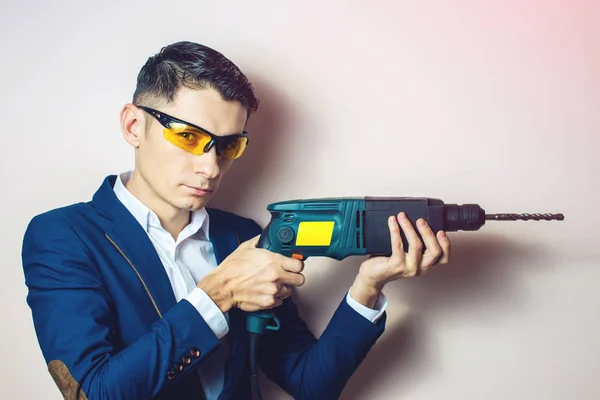 Uomo d'affari tiene in mano un trapano elettrico come arma — Foto Stock