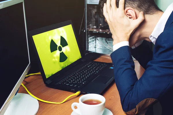 man holding his head looking at the monitor infected computer
