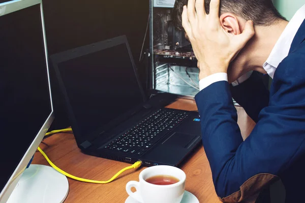 Muž, který držel hlavu při pohledu na monitor rozbité počítače — Stock fotografie