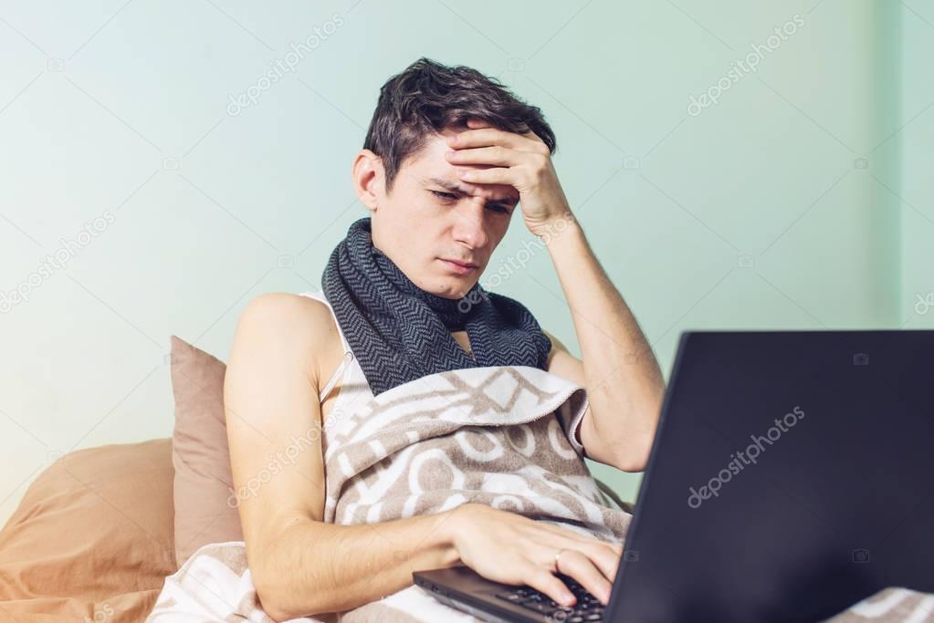 young man sick with a cold lying in bed