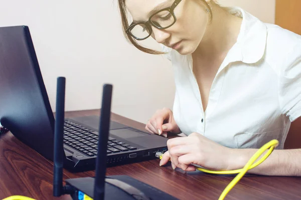 Wanita menghubungkan kabel internet ke konektor pada laptop — Stok Foto