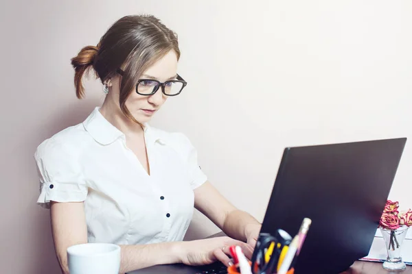 Bir dizüstü bilgisayarda yazarak gözlük ile çekici kız — Stok fotoğraf