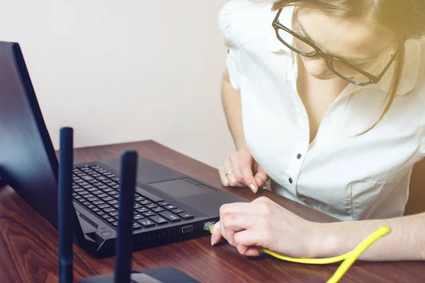 Kadın laptop konektörüne enterne tel kablo bağlamak — Stok fotoğraf