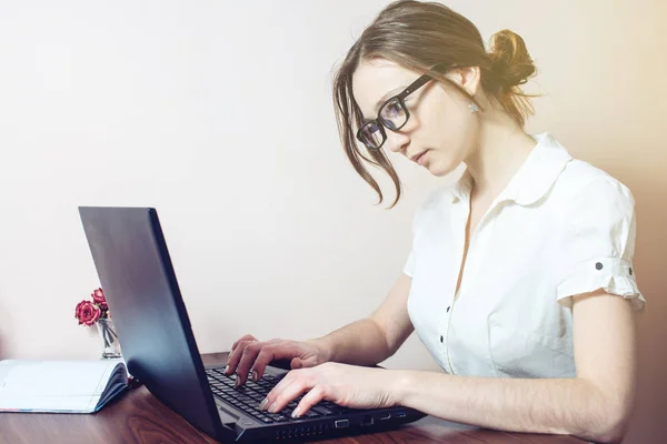Jolie fille avec les lunettes dactylographier sur un ordinateur portable — Photo