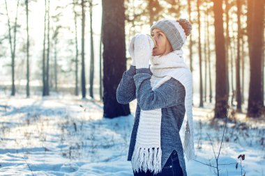 Kış güneş ışığı üzerinde sıcak çay içme çekici kadın