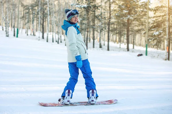 Snowboarder feminino snowboard descendo a montanha — Fotografia de Stock