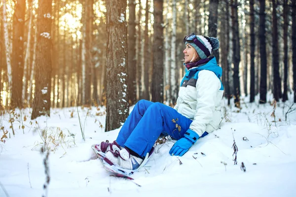Mulher snowboarder com snowboard está descansando sentado na neve — Fotografia de Stock