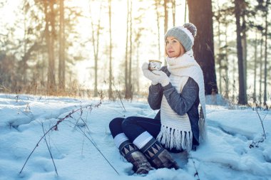Kış güneş ışığı üzerinde sıcak çay içme çekici kadın