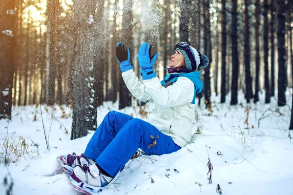 Kadın Snowboard snowboard ile kar üzerinde oturmuş dinleniyor