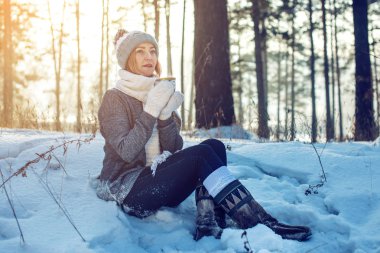 Kış güneş ışığı üzerinde sıcak çay içme çekici kadın