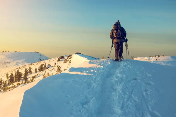 Hombre excursionista va en las montañas a través de la nieve —  Fotos de Stock