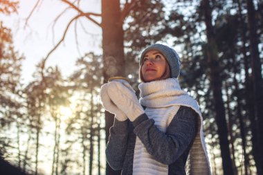 Kış güneş ışığı üzerinde sıcak çay içme çekici kadın