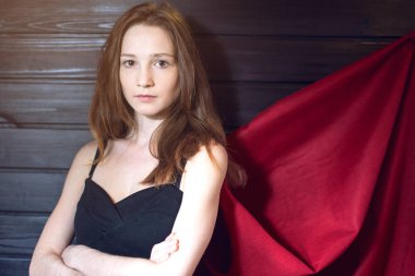 Süper kadın memur bir takım elbise ve kırmızı pelerin ayakta