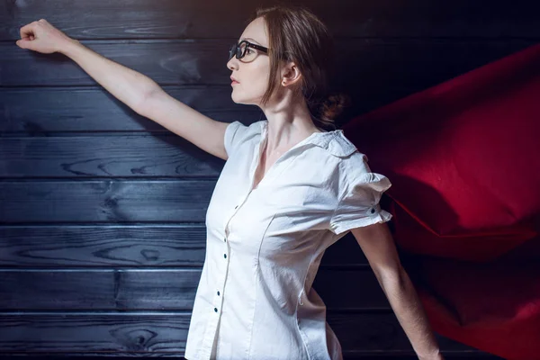 Работница офиса суперженщины, стоящая в костюме и красном плаще — стоковое фото