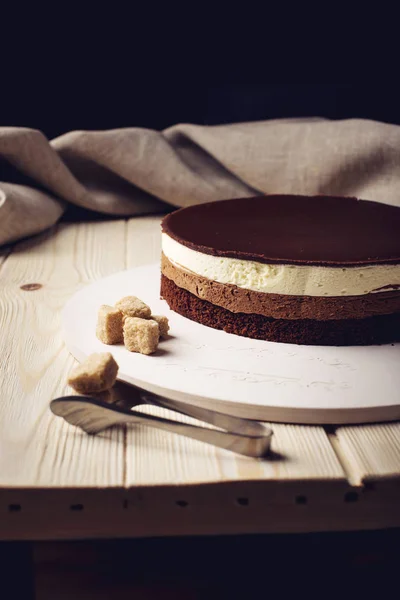 Вкусный трехслойный шоколадный торт стоит на круглой основе — стоковое фото