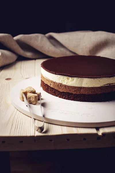 Deliziosa torta al cioccolato a tre strati si erge su una base circolare — Foto Stock