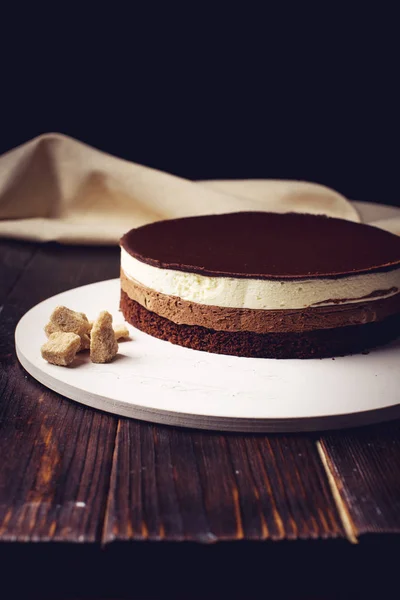 Вкусный трехслойный шоколадный торт стоит на круглой основе — стоковое фото