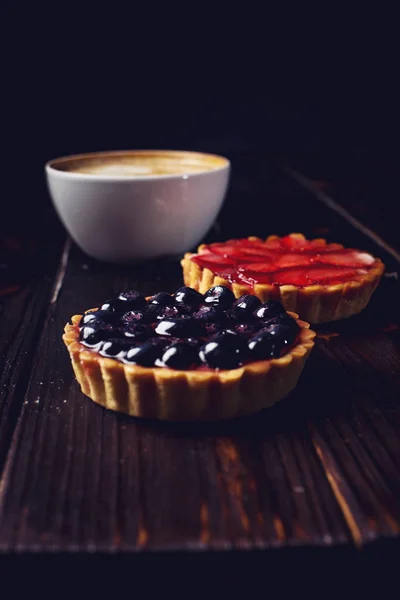 Berry tarts with strawberries and blueberries next Cup of coffee