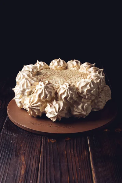 Beautiful white Meringue cake stands on wooden table dark background — Stock Photo, Image