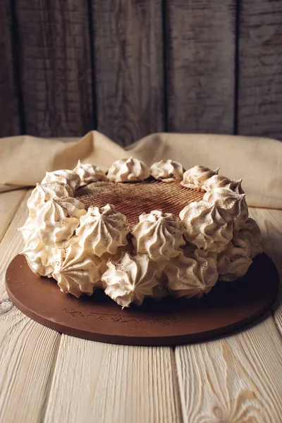 Vit maräng tårta, beströs med kakao på ett träbord — Stockfoto