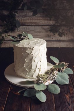 yeşil yaprakları ile süslenmiş beyaz kremalı pasta