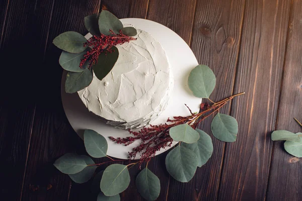 Λευκή τούρτα διακοσμημένη με πράσινα φύλλα — Φωτογραφία Αρχείου