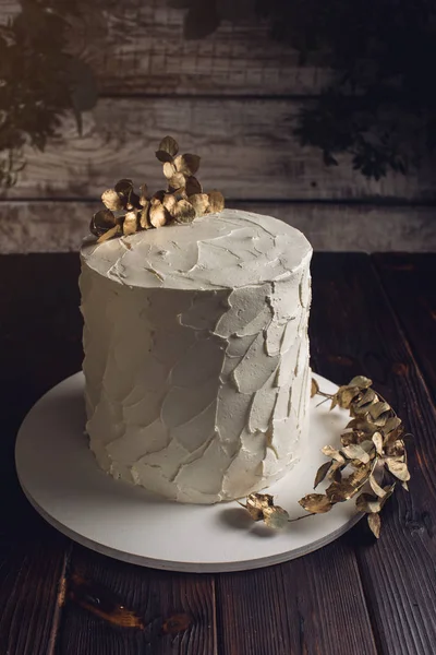 Λευκή τούρτα διακοσμημένη με ένα κλαδί με φύλλα χρυσού — Φωτογραφία Αρχείου