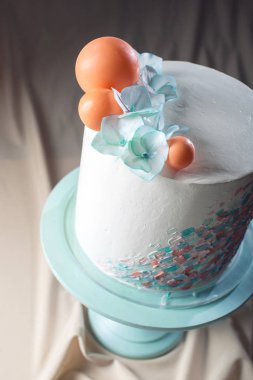 Düğün pastası pastel tarz ile mavi çiçekler ve turuncu topları