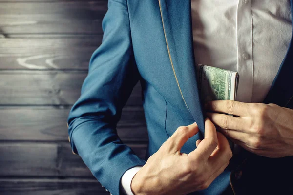 stock image Businessman, member or officer puts a bribe in his pocket