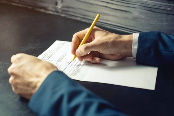 Man lawyer or official signs documents with a pen