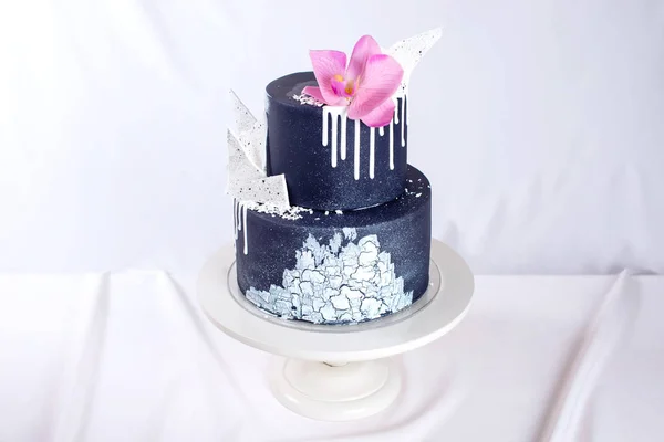 黑色婚礼蛋糕装饰着白色的巧克力和兰花花 — 图库照片
