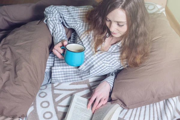 Ragazza carina che legge un libro mentre si trova a letto — Foto Stock