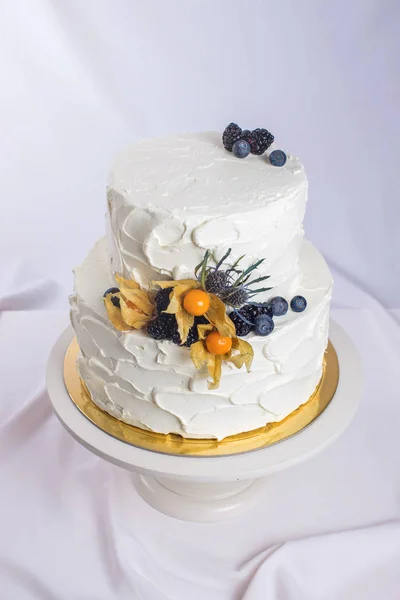 Pastel de crema blanca de dos niveles decorado con bayas —  Fotos de Stock