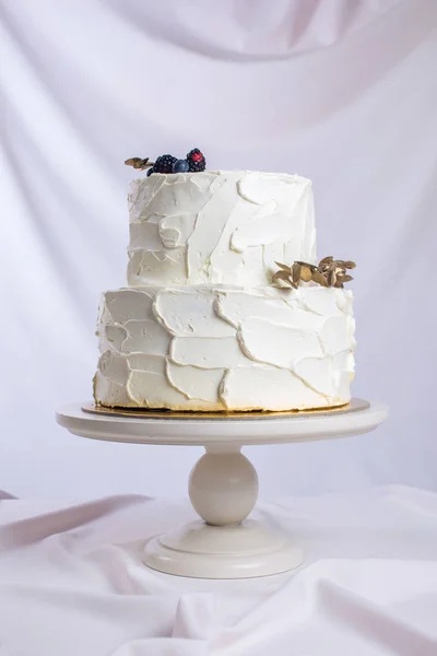 Λευκή τούρτα διακοσμημένη με ένα κλαδί με φύλλα χρυσού — Φωτογραφία Αρχείου