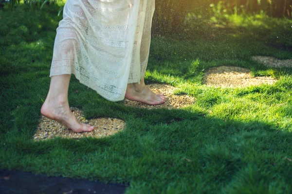 Fille marchant pieds nus sur les pierres en forme de coeur — Photo