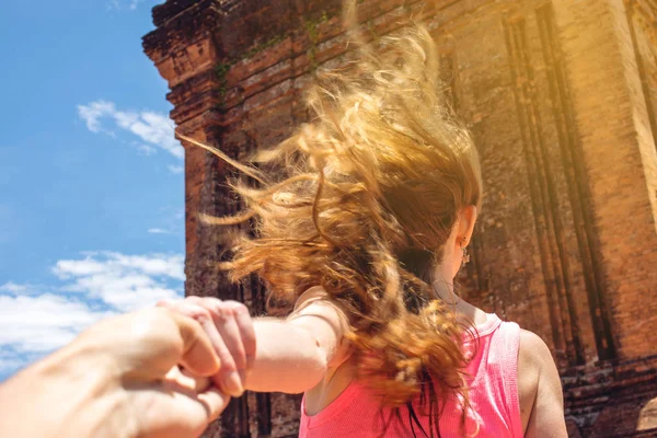 Mulher descobrindo um templo antigo segurando a mão do namorado . — Fotografia de Stock